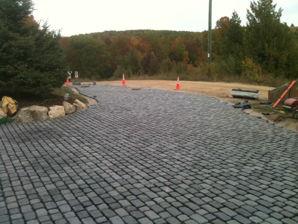 gray rounded paver stones that meet a dirt road