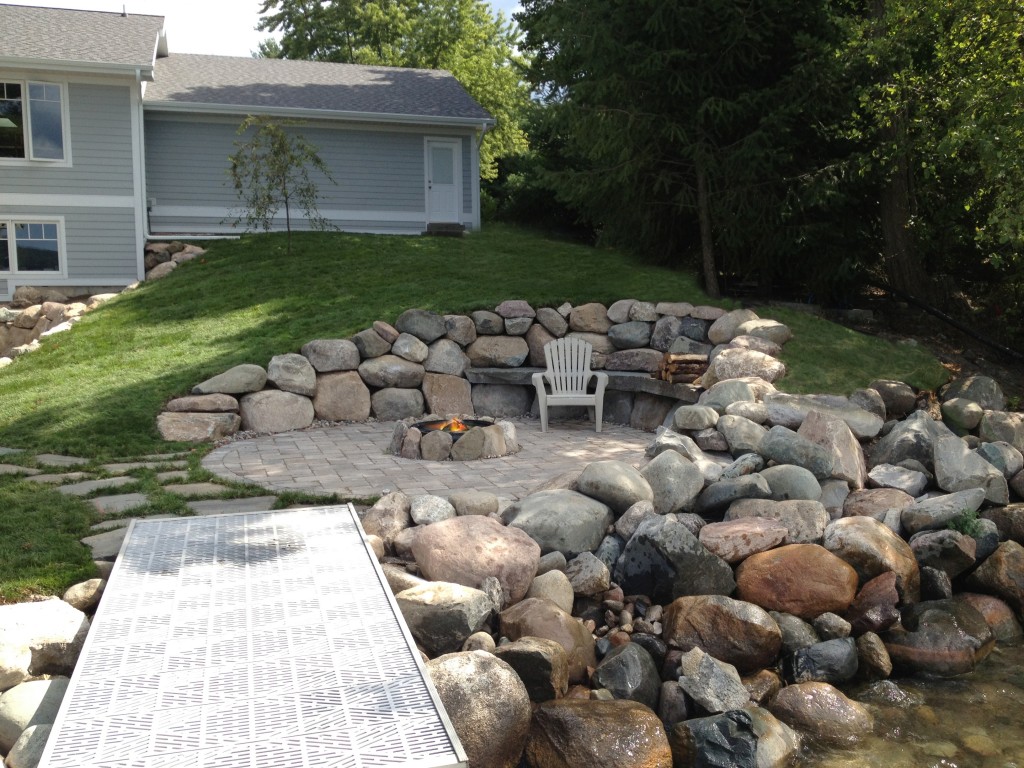 large rock retaining wall landscape feature with fire pit