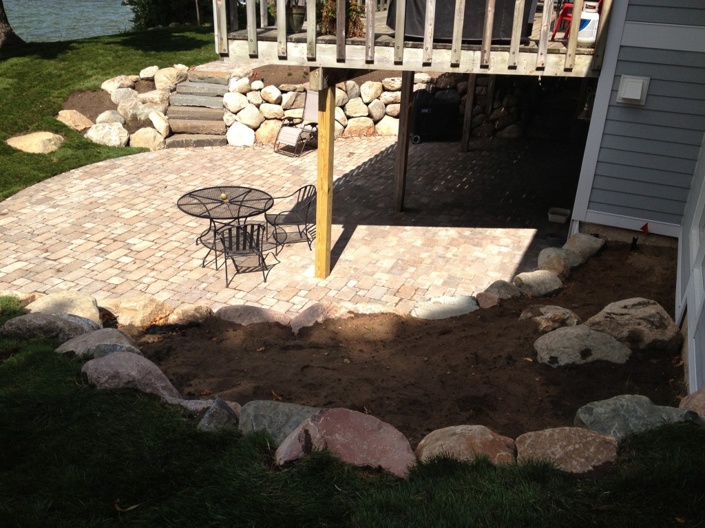 backyard landscaped using a mixture of large stones and pavers