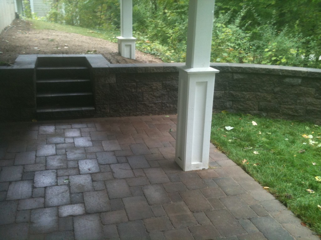 paved basement walkout with wooded surroundings