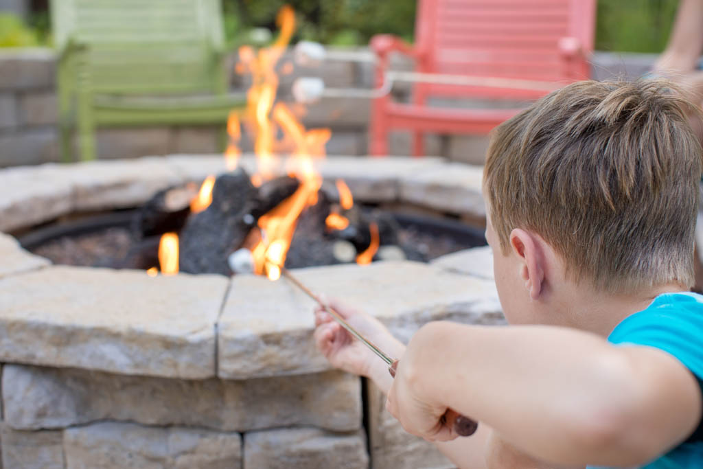 little boy roasting a marshmallow in the fire place