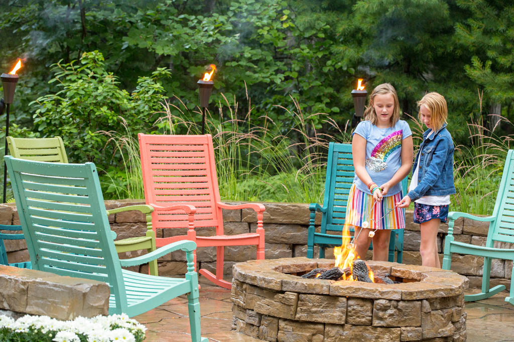 little girls stand over fire roasting marshmallows