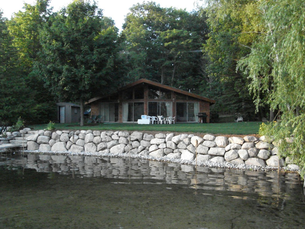 rock retaining wall between lake and lawn