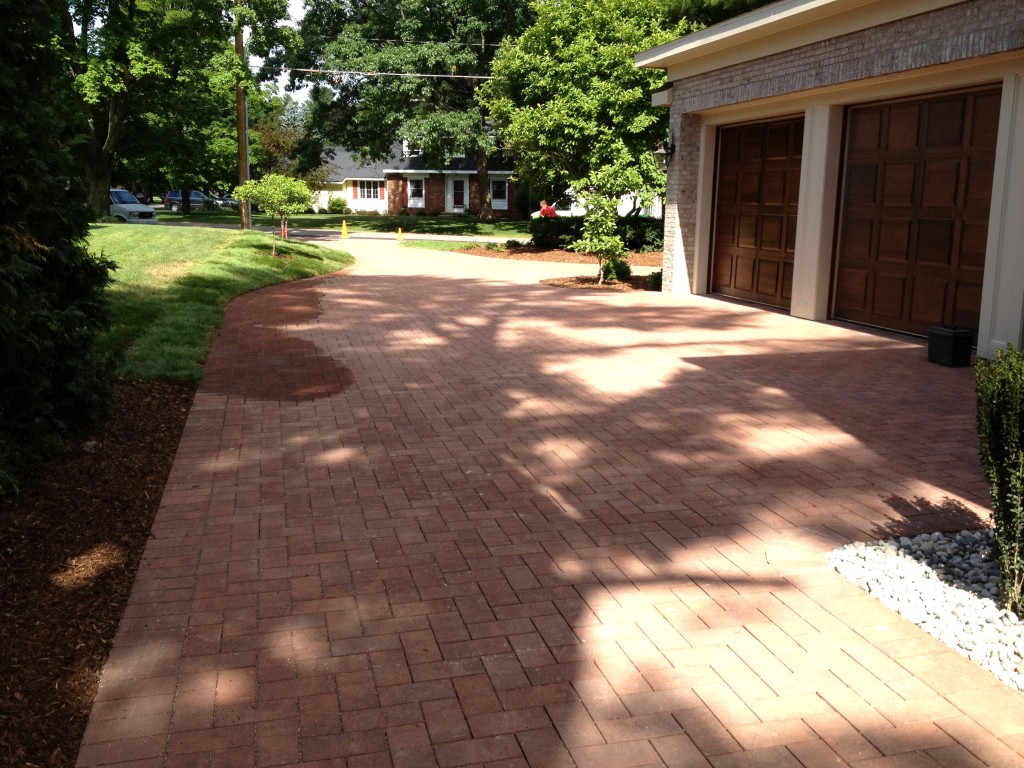 two door garage with brick driveway