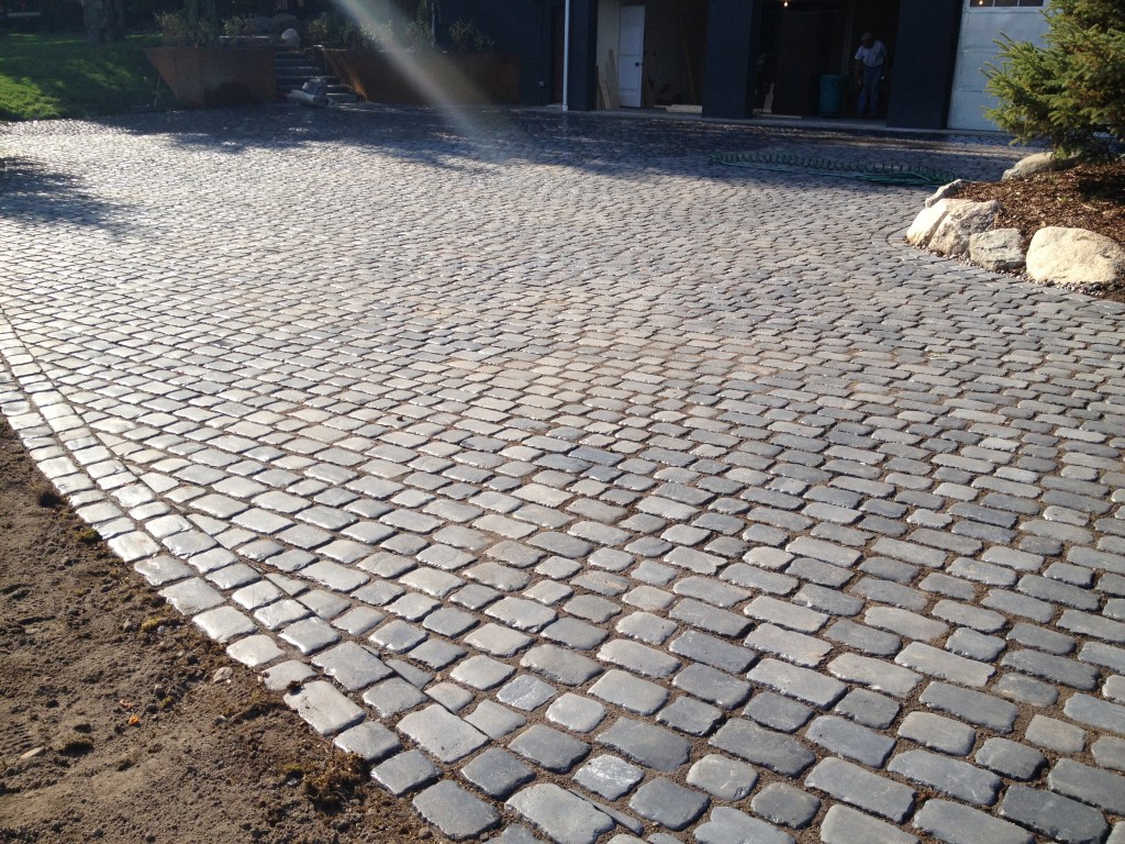 rounded gray paved stone surface in front of garage 