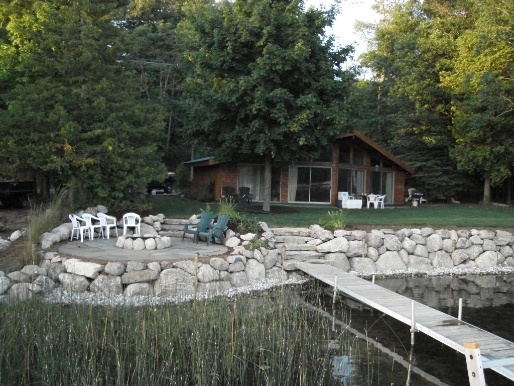 rocky fire pit patio with dock and cottage