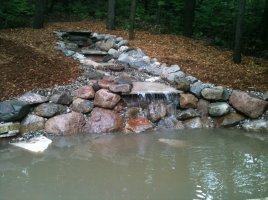 custom made water fall into man made pond