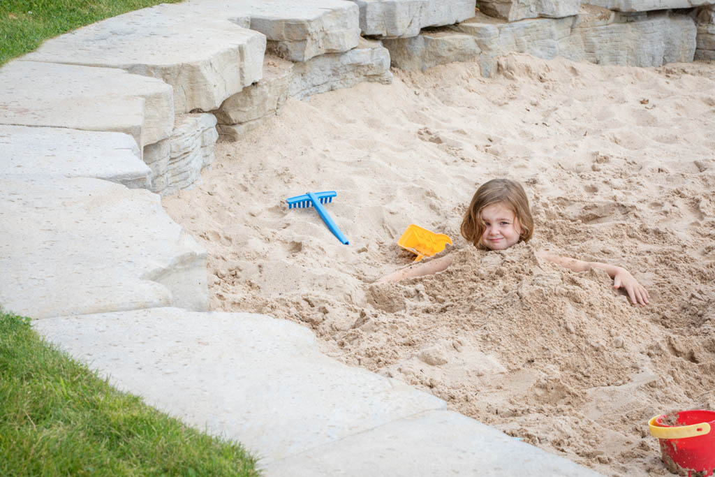 sandbox with plastic blue rack and a red pale