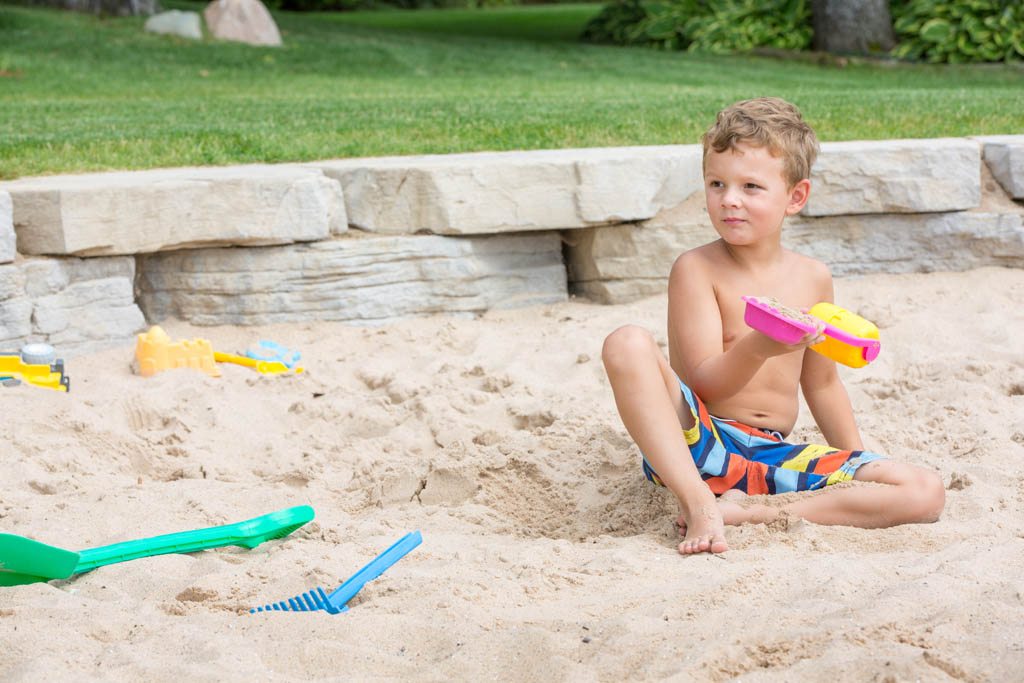 small boy sitting in the sand