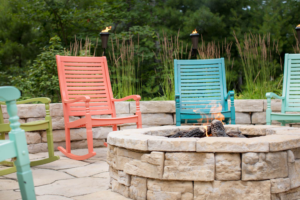 multi colored rocking chairs surrounding above ground fire place