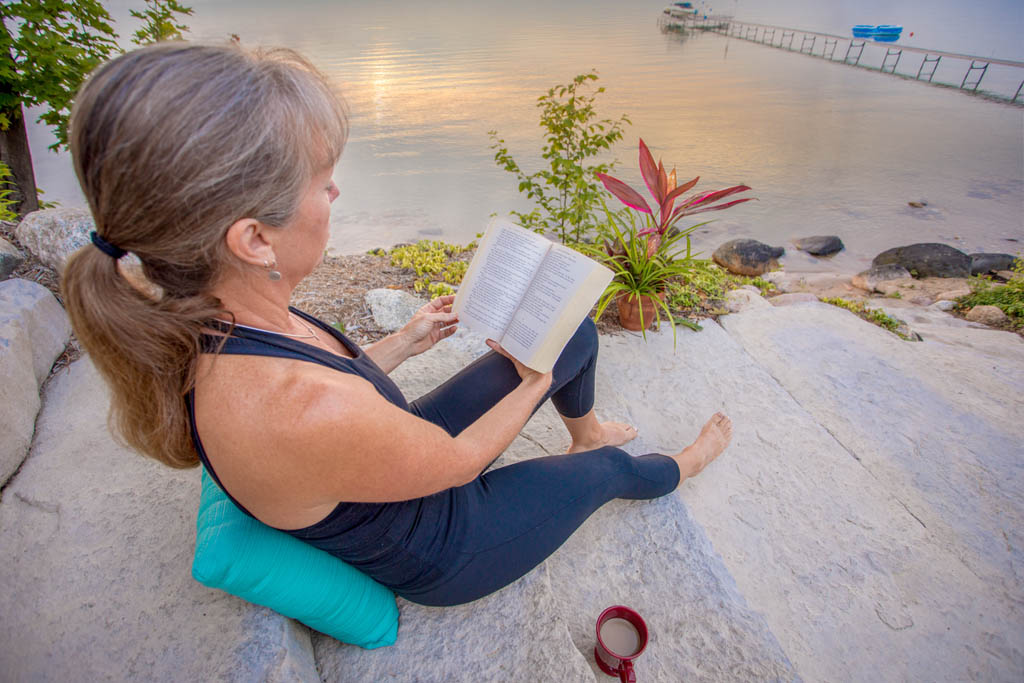 woman reading a book and enjoying a cup of coffee